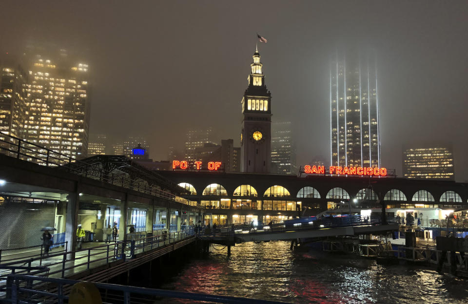 In this photo taken Tuesday, Nov. 27, 2018, rain showers begin to diminish at the Ferry Building in San Francisco. Forecasters say California will see widespread rain and heavy Sierra Nevada snowfall starting late Wednesday that could create travel problems and unleash damaging runoff from wildfire burn scars. (AP Photo/Eric Risberg)