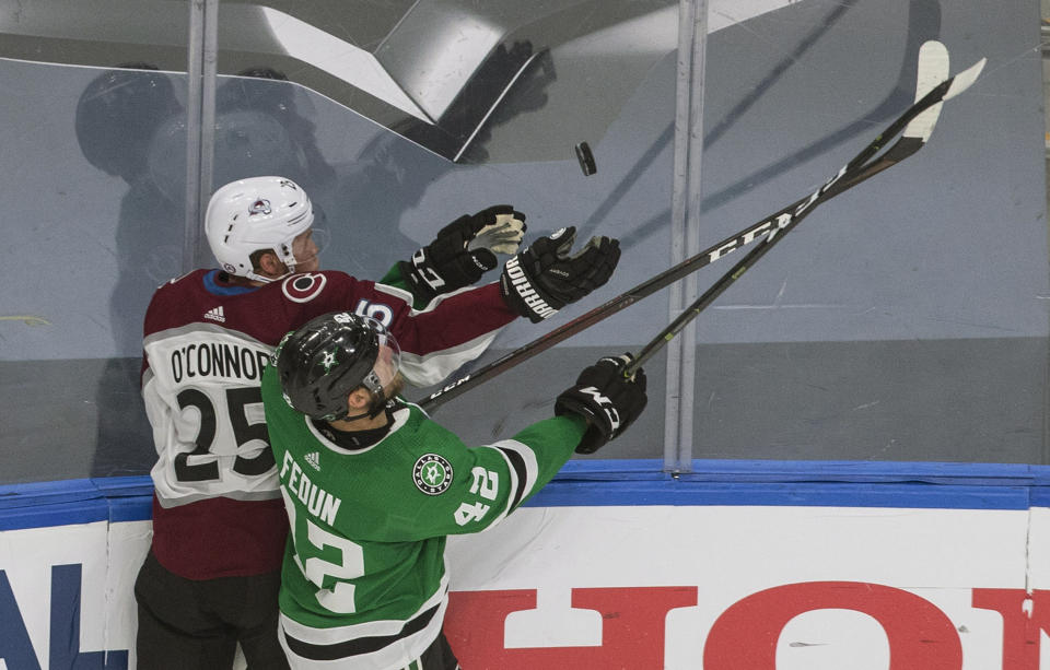 Dallas Stars' Taylor Fedun (42) and Colorado Avalanche's Logan O'Connor (25) reach for a loose puck during the third period of an NHL hockey second-round playoff series, Sunday, Aug. 30, 2020, in Edmonton, Alberta. (Jason Franson/The Canadian Press via AP)