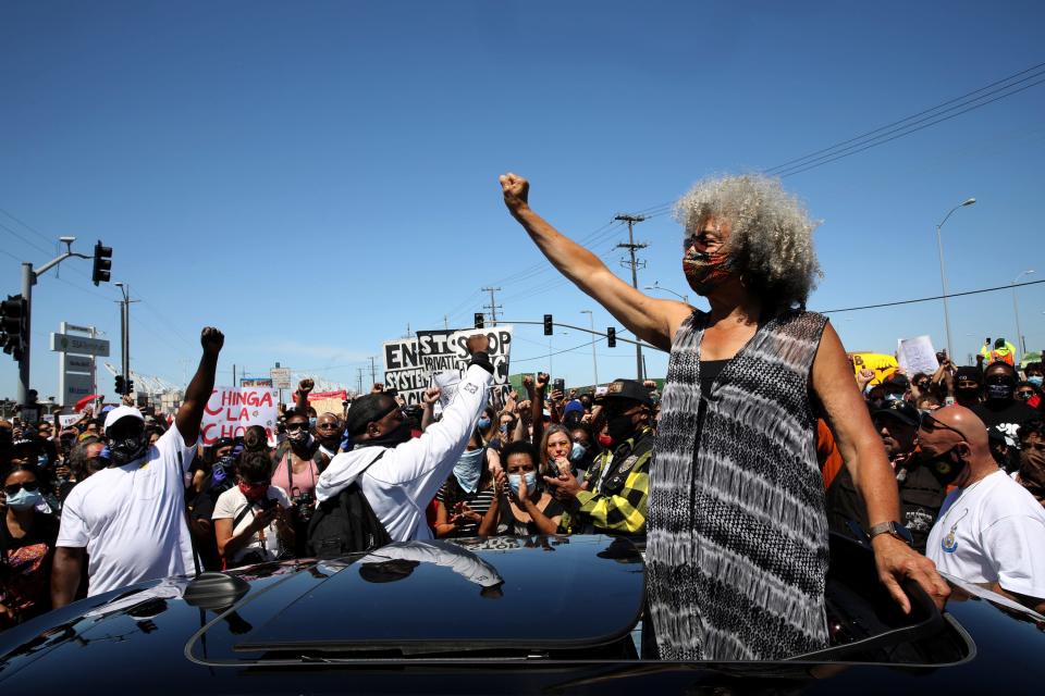 Activist Angela Davis pumps her fist during a Juneteenth shut down at the Port of Oakland, Friday, June 19, 2020, in Oakland, Calif.