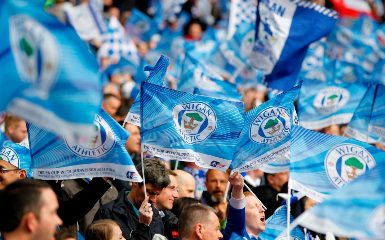 Wigan Athletic fans wave flags - AFP