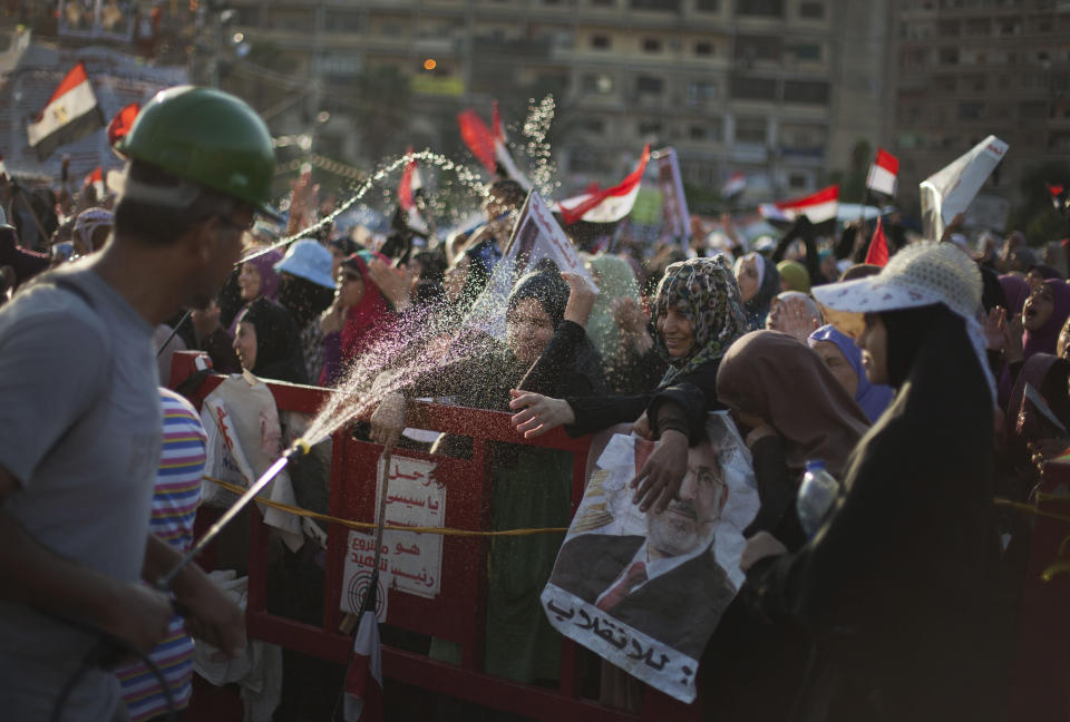 A supporter of Egypt's ousted President Mohammed Morsi sprays water at protesters outside Rabaah al-Adawiya mosque, where protesters have installed a camp and hold daily rallies at Nasr City in Cairo, Egypt, Thursday, Aug. 1, 2013. (AP Photo/Khalil Hamra)