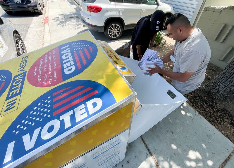 FILE PHOTO: Polling workers empty a curbside ballot box in Santa Monica