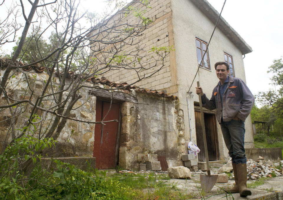 Cain Burdeau stands in front of former barns in Castelbuono, Sicily, on April 13, 2021, that he plans to convert into a family home. (AP Photo/Audrey Rodeman)