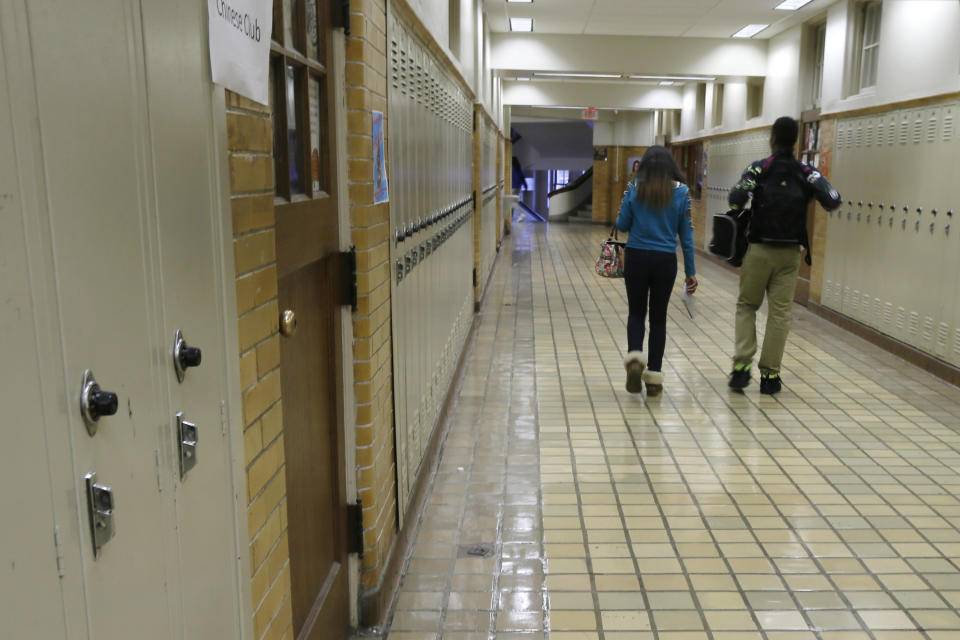 FILE - In this Monday, Jan. 13, 2014, file photo, two students walk in a hallway at Little Rock Central High School in Little Rock, Ark. Arkansas can stop making payments in one of the nation's most historic desegregation efforts, a judge has ruled, but he cautioned work remains to ensure students in the Little Rock area receive a proper education. (AP Photo/Danny Johnston, File)