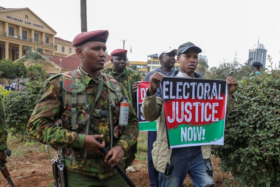 Supporters of Kenya’s opposition leader gather as police officers keep guard (REUTERS)