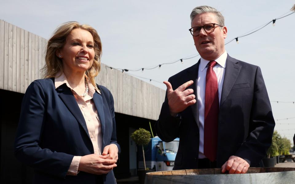 Natalie Elphicke stands with Sir Keir Starmer, who rests his hand on top of a barrel