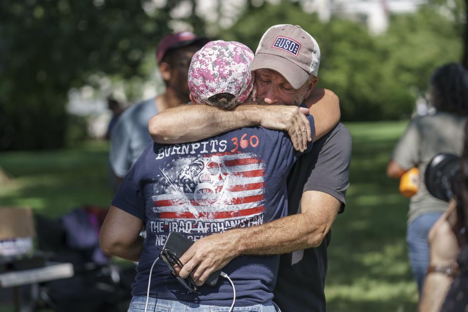 Activist and entertainer Jon Stewart hugs fellow advocate Susan Zeier of Sandusky, Ohio, just after Senate Majority Leader Chuck Schumer, D-N.Y., assured veterans and military family members that the Senate will vote on a bill designed to help millions of veterans exposed to toxic substances during their military service, at the Capitol in Washington, Tuesday, Aug. 2, 2022. (AP Photo/J. Scott Applewhite)