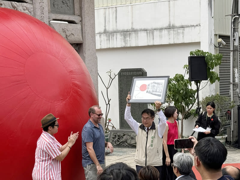 「紅球計畫」藝術家贈黃偉哲手繪圖 美國藝術家波希克（Kurt Perschke）（左2）在台南市 發起「紅球計畫」，29日還贈送一幅紅球手繪圖給台 南市長黃偉哲（左3），黃偉哲高興地向眾人展示。 中央社記者張榮祥台南攝  113年3月29日 