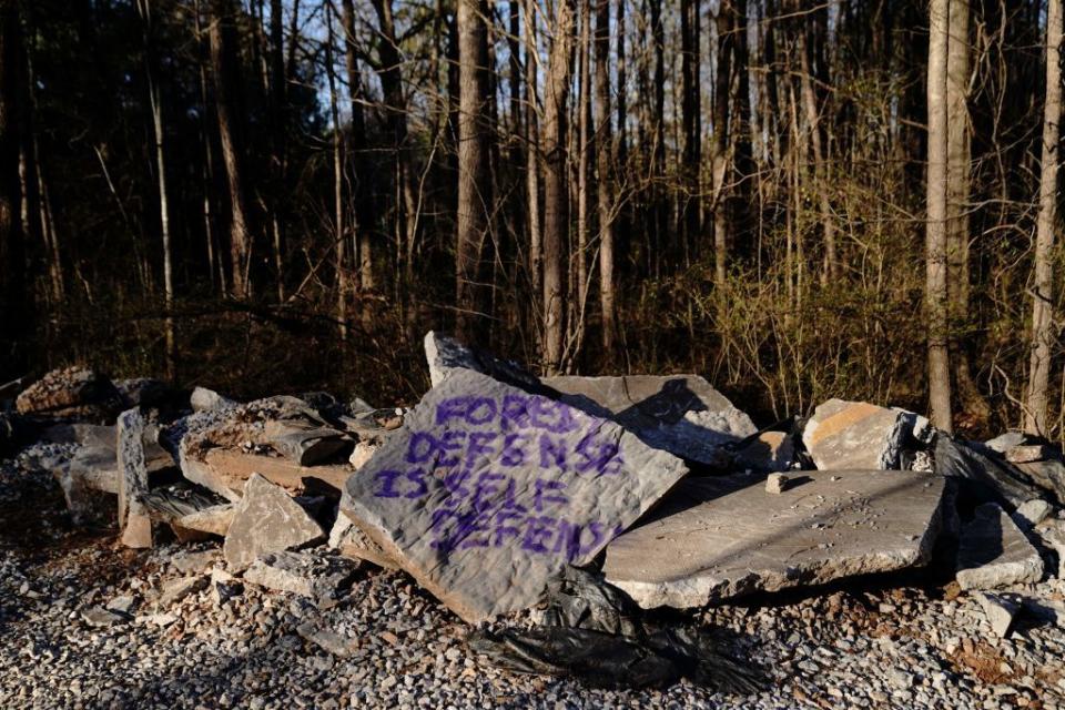 graffiti on a rock that reads forest defense is self defense