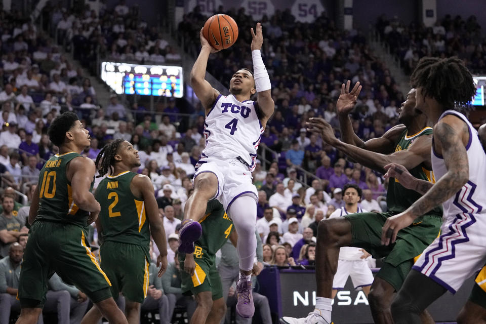 TCU guard Jameer Nelson Jr. (4) lays up to shoot between Baylor's RayJ Dennis (10), Jayden Nunn (2) and Yves Missi, second from right, as TCU's Micah Peavy, right, looks on in the first half of an NCAA college basketball game in Fort Worth, Texas, Monday, Feb. 26, 2024. (AP Photo/Tony Gutierrez)