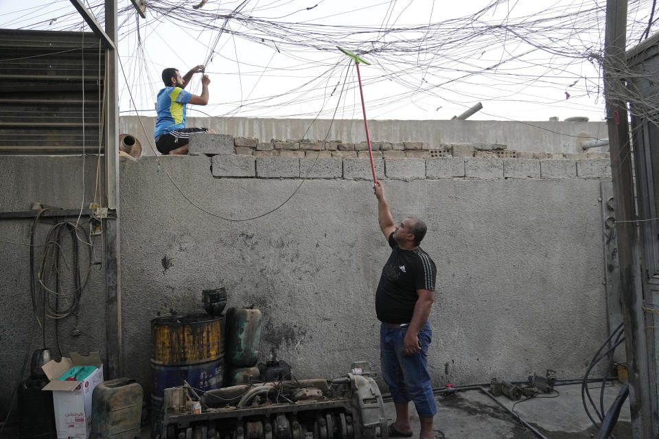 Electricians work on a network of generator wires during a power outage in Baghdad, Iraq, July 13, 2022. Private generators are ubiquitous in parts of the Middle East, spewing hazardous fumes into homes and business across the country, almost 24 hours a day. As the world looks for renewable energy to tackle climate change, Lebanon, Iraq, Gaza and elsewhere rely on diesel-powered private generators just to keep the lights on. The reason is state failure: In multiple countries, governments can’t maintain a functioning central power network, whether because of war, conflict or mismanagement and corruption. (AP Photo/Hadi Mizban)