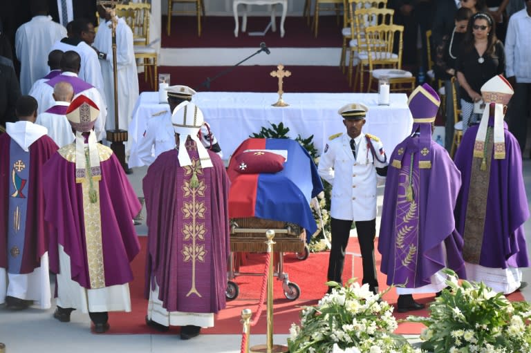 Police officers from the National Palace stand next to the casket of former Haitian president Rene Preval during the State Funeral at the kioske Occide Jeanty, in Port-au-Prince, on March 11, 2017