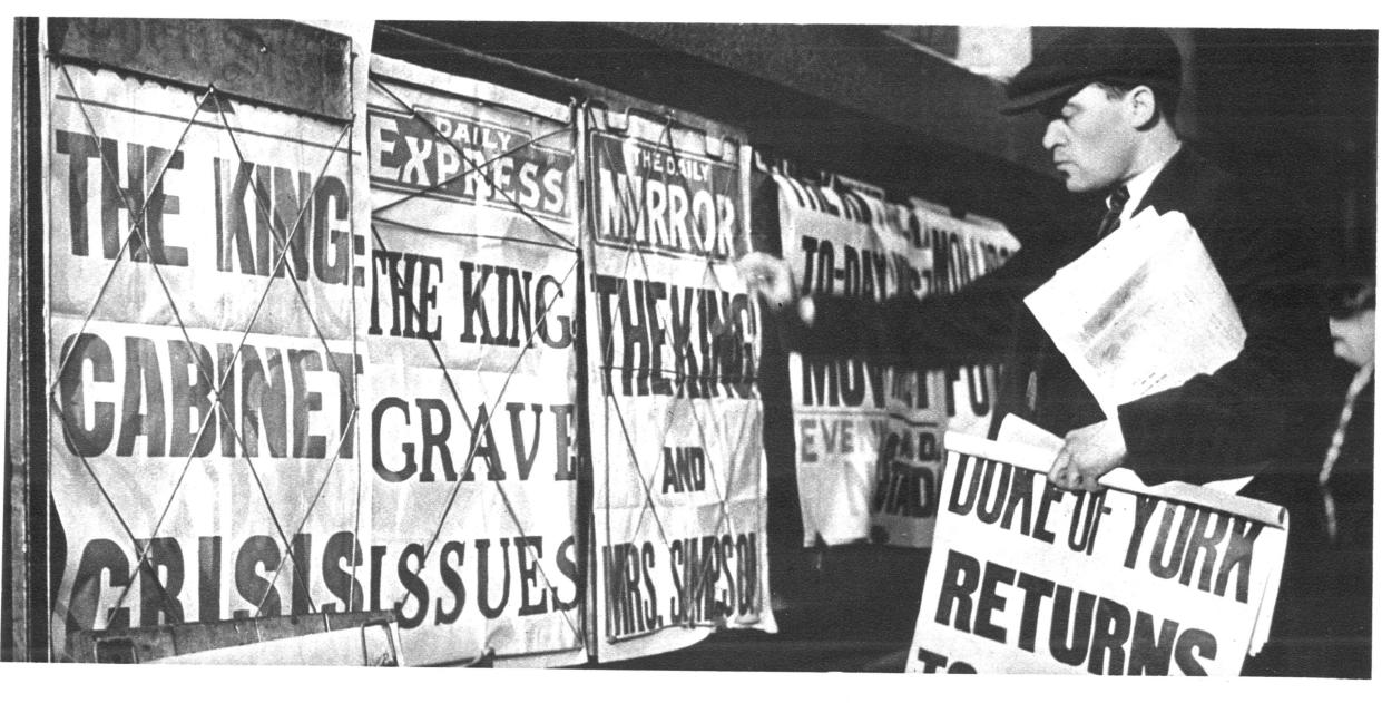 Newspaper seller adjusting his headline posters during the Edward VIII abdication crisis of 1937 (Photo by: Universal History Archive/Universal Images Group via Getty Images)