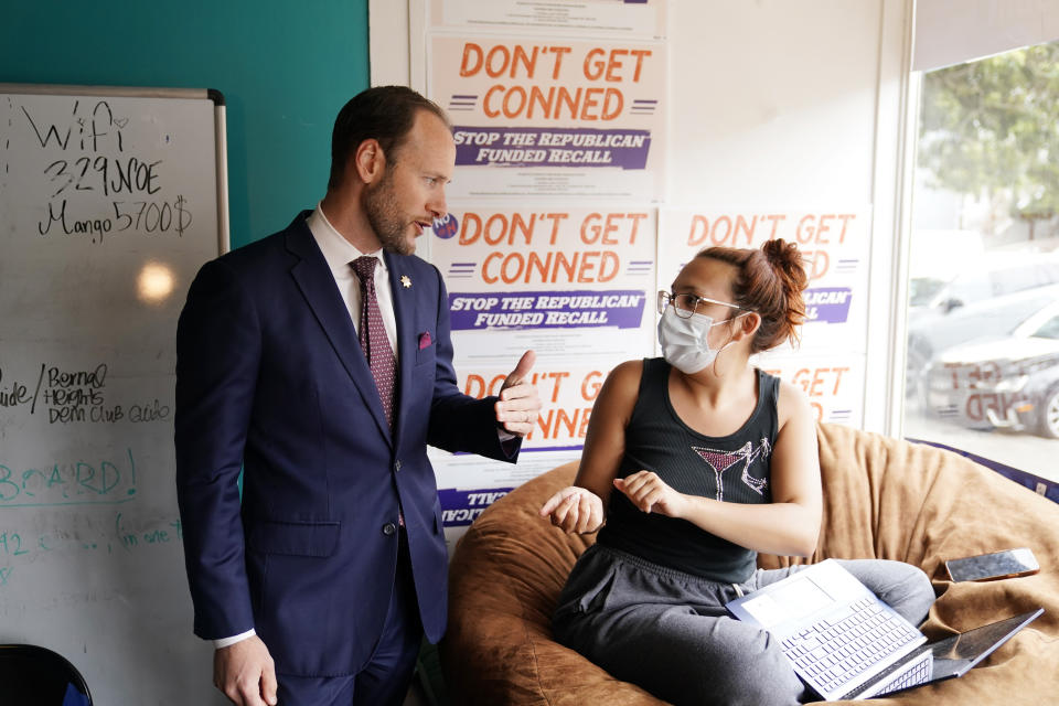 San Francisco District Attorney Chesa Boudin, left, talks with a volunteer at his campaign headquarters in San Francisco, on May 26, 2022. Politically liberal San Francisco could vote out one of the most progressive prosecutors in the country nearly three years after Boudin was elected. His time in office coincided with a pandemic in which brutal attacks against Asian seniors and viral footage of rampant shoplifting fueled a rare campaign to remove him. (AP Photo/Eric Risberg)