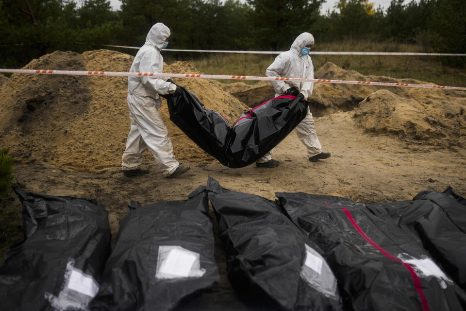 Members of a forensic team carry a plastic bag with a body inside as they work in an exhumation in a mass grave in Lyman, Ukraine, Tuesday, Oct. 11, 2022. This was the year war returned to Europe, and few facets of life were left untouched. Russia’s invasion of its neighbor Ukraine unleashed misery on millions of Ukrainians, shattered Europe’s sense of security, ripped up the geopolitical map and rocked the global economy. The shockwaves made life more expensive in homes across Europe, worsened a global migrant crisis and complicated the world’s response to climate change. (AP Photo/Francisco Seco)