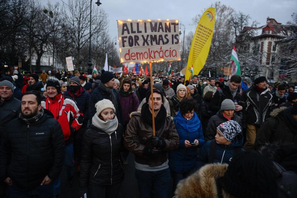 群眾高舉著「我要的耶誕節禮物是民主」牌子，上街抗議。（東方IC）