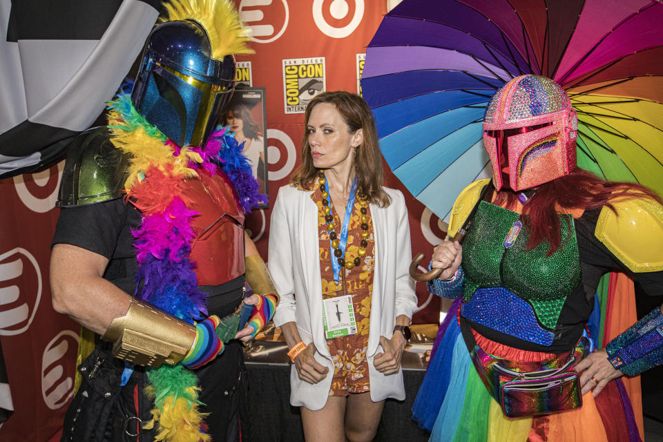 SAN DIEGO, CALIFORNIA - JULY 22: Actress Emily Swallow (C) poses with Mandalorian cosplayers Shawn Richter as Pride Mando and Lisa Lower as Sparkle Fett at 2022 Comic-Con International Day 2 at San Diego Convention Center on July 22, 2022 in San Diego, California. (Photo by Daniel Knighton/Getty Images)