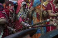 <p>Indian women from the north Indian village Nandgaon use large sticks to hit men holding shields as they participate in the celebrations of Lathmaar Holi on March 18, 2016. </p>