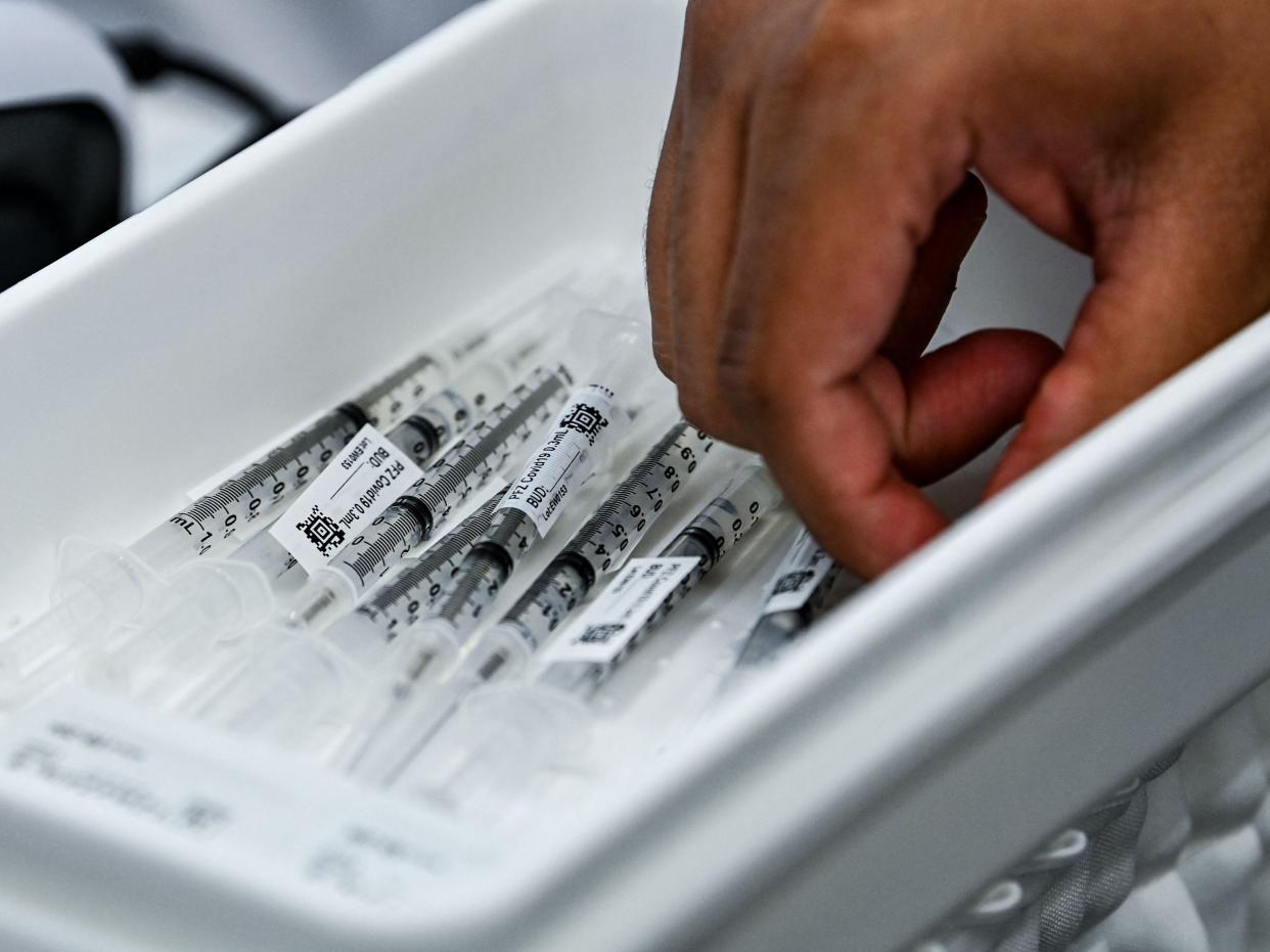 <p>Pharmacy student Jason Rodriguez prepares Pfizer vaccines at the Christine E. Lynn Rehabilitation Center in Miami, Florida on 15 April, 2021</p> (AFP via Getty Images)