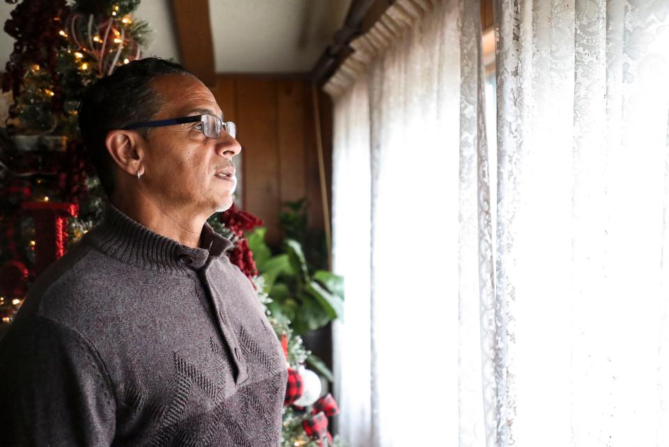 Michael Jurado looks out the window of the home he shares with his mother on Tuesday, Dec. 14, 2021, in Hemet, Calif. Jurado spent more than three decades in prison for violent crimes he committed in the 1980s. Ever since he was paroled he has been working with Starting Over Inc., a criminal justice advocacy group, to help families who are faced with the challenges of an incarcerated loved one.