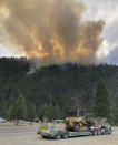 In this photo provided by Caltrans, smoke rises from the Head Fire in Klamath National Forest, Calif., on Tuesday Aug. 15, 2023. A wildfire pushed by gusty winds from a thunderstorm raced through national forest land near California's border with Oregon, prompting evacuations in the rural area. The blaze in Siskiyou County was one of at least 19 fires — most of them tiny — that erupted in the Klamath National Forest as thunderstorms rolling through the area brought lightning and downdrafts that drove the flames through timber and rural lands. (Roger Matthews/Caltrans via AP)