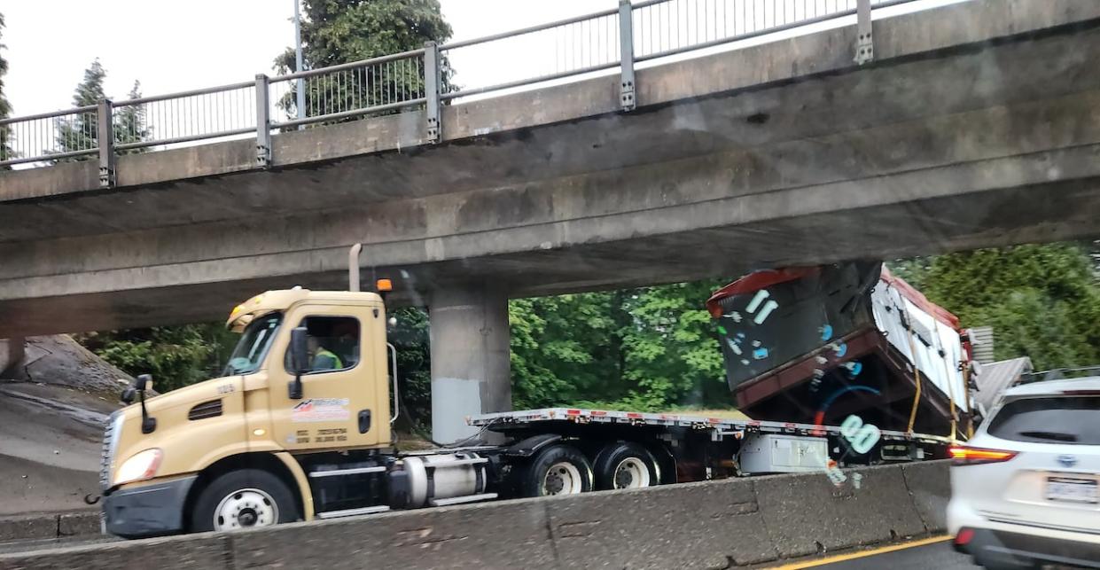 A container truck hit an overpass in North Vancouver on Tuesday, forcing the closure of the Trans-Canada Highway. (Miller Capilano Highway Services/Twitter - image credit)