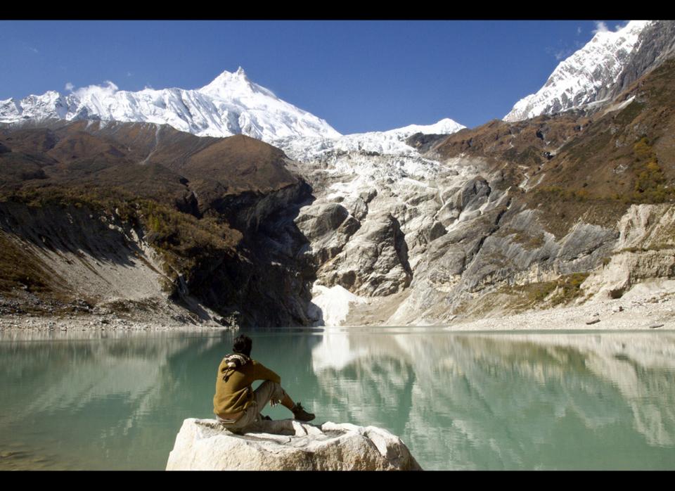 In this Oct. 19, 2011 file photo courtesy of SNV Nepal, Great Himalaya Trail Development Programme, a trekker sits by Birendra Lake in the Manaslu region, part of the Great Himalaya Trail route, in Nepal. In the shadow of Mount Everest and its magnetic lore, a cross-border route with a grand name, the Great Himalaya Trail, is being touted as an epic, untapped alternative to the bucket-list trek to base camp on the world's highest mountain. (AP Photo/SNV Nepal, Great Himalaya Trail Development Programme, Samir Thapa, File)