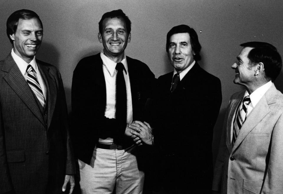 In 1980: Left, Haly Dyer, former scout for the Los Angeles Rams and Edmonton Muskies, and right, Charlie Winner, a former coach for the Cincinnati Bengals are amused as Gerry Faust, Moeller coach and Pat Mancuso, Princeton coach, shake hands at a pre-production meeting at the Warner Mex Studio Oct. 16.