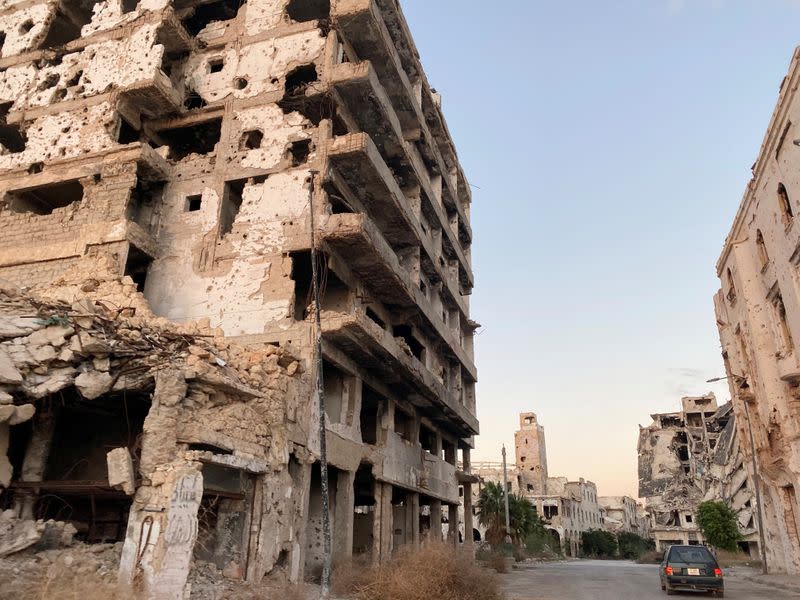 Car is seen between destroyed buildings in Benghazi