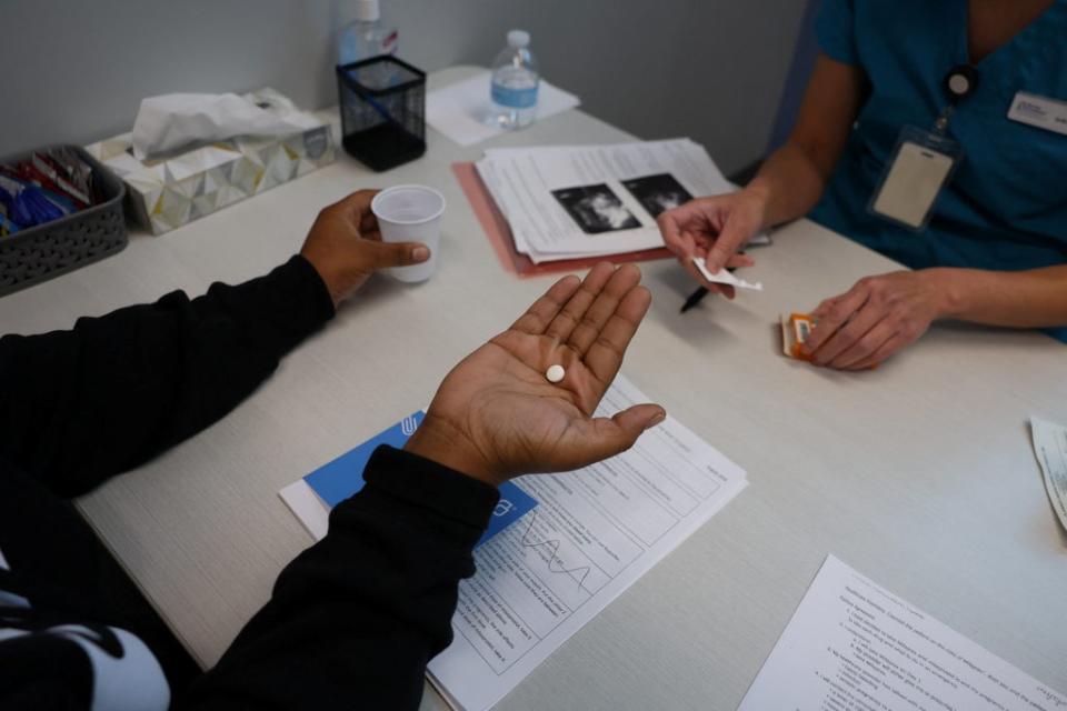 Tien gives a patient medication to start a medical abortion (Reuters)