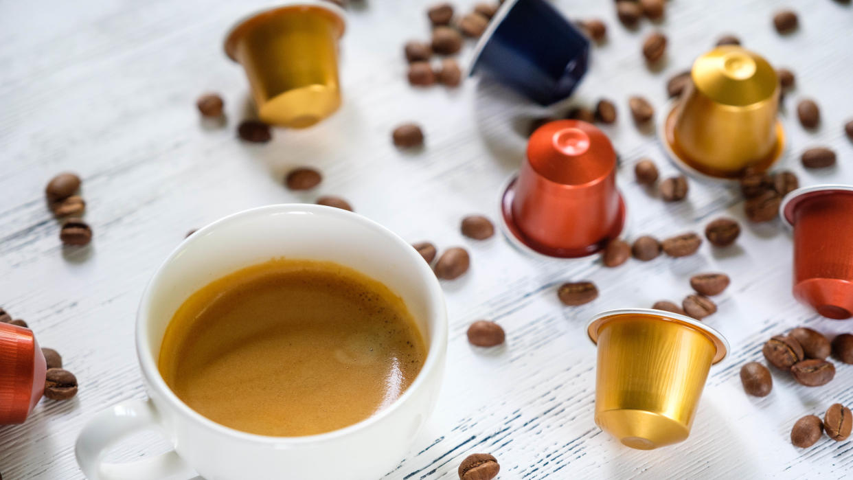  Cup of coffee with coffee pods and beans. 