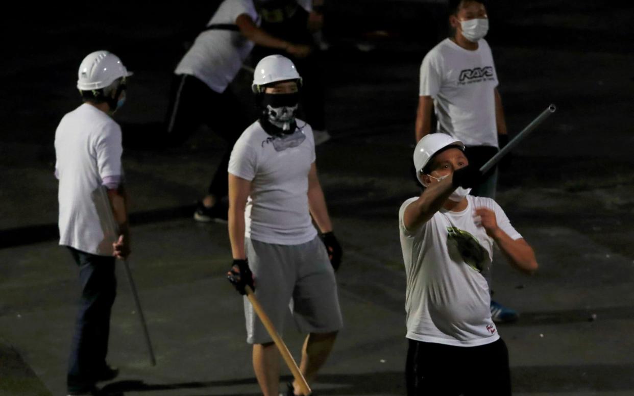Some of the men in white shirts were filmed leaving the scene in cars bearing Chinese mainland number plates - REUTERS