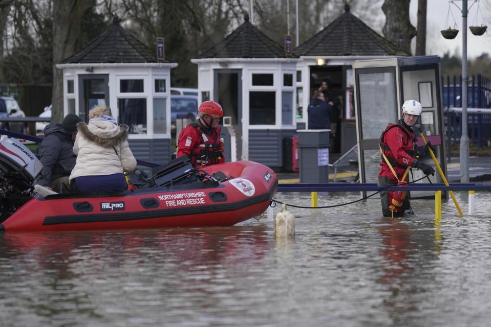 Northamptonshire Fire and rescue service rescue people from houseboats at the Billing Aquadrome in Northampton, England, Wednesday, Jan. 3, 2023, after the pathway to land was blocked due to rising water caused by Storm Henk. A severe flood alert, meaning danger to life, was in place for the River Nene in Northampton. (Jacob King/PA via AP)