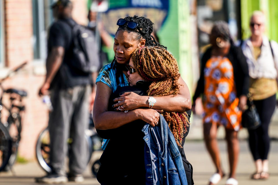 People embrace outside the scene of a shooting at a supermarket in Buffalo, N.Y., on May 15, 2022. (Matt Rourke / AP)