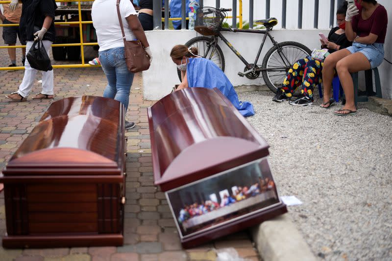 People wait next to coffins outside Guasmo Sur General Hospital after Ecuador reported new cases of coronavirus disease (COVID-19), in Guayaquil