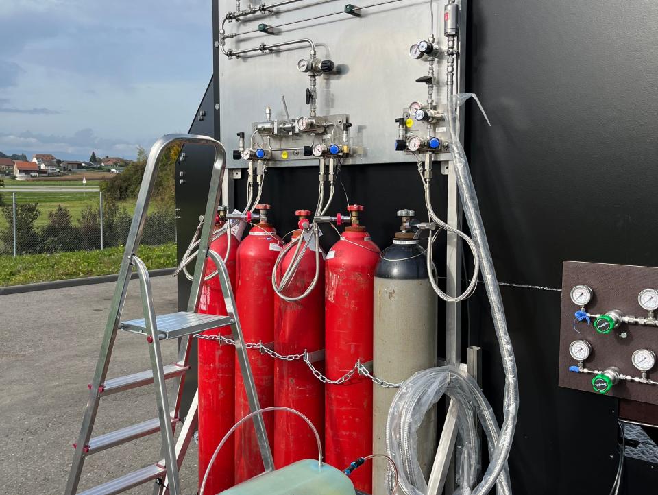 Hydrogen testing stand with red and beige tanks.