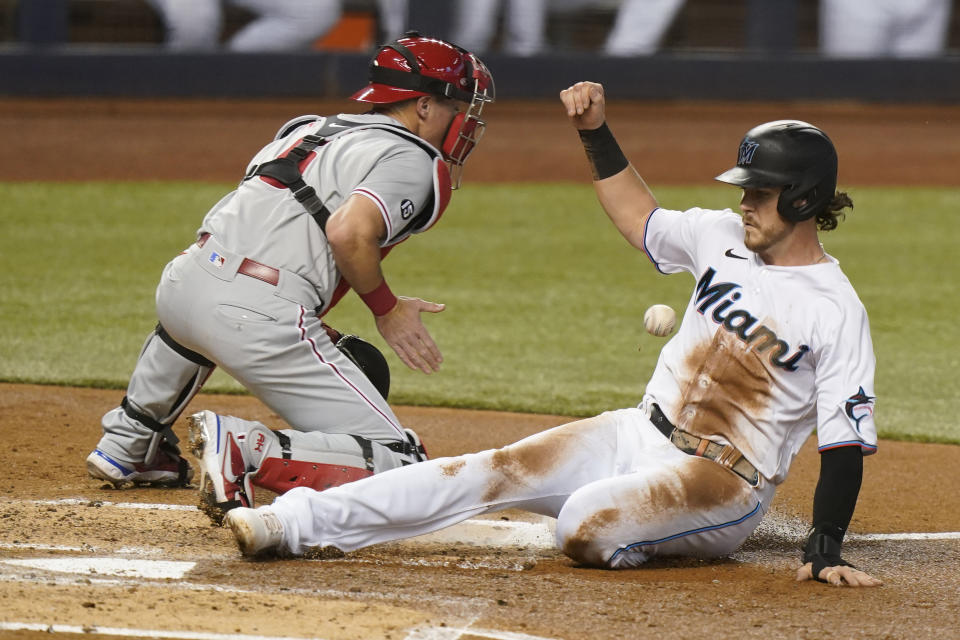 Miami Marlins' Brian Anderson, right, is safe at home on a sacrifice fly by Sandy Leon as Philadelphia Phillies catcher Andrew Knapp waits for the throw during the second inning of a baseball game, Monday, May 24, 2021, in Miami. (AP Photo/Wilfredo Lee)