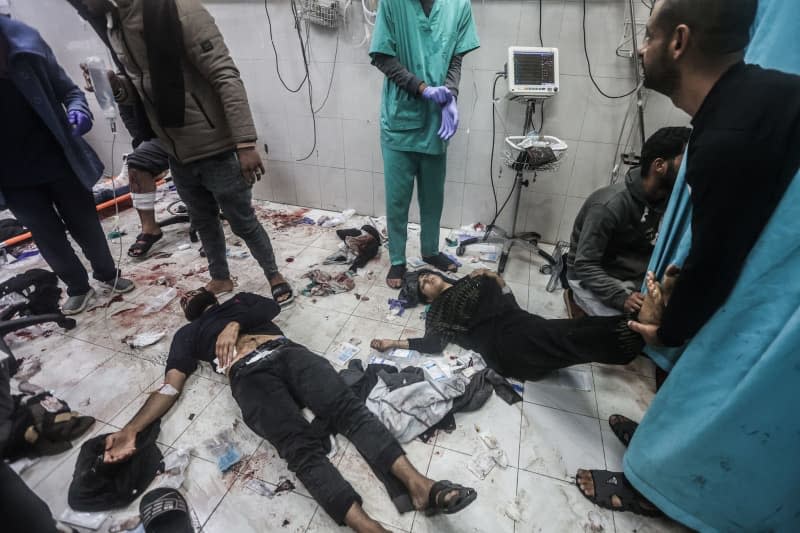 Palestinians injured during an Israeli bombing receive treatment while lying on the floor of Nasser Hospital.  Ahmed Zaqout/dpa