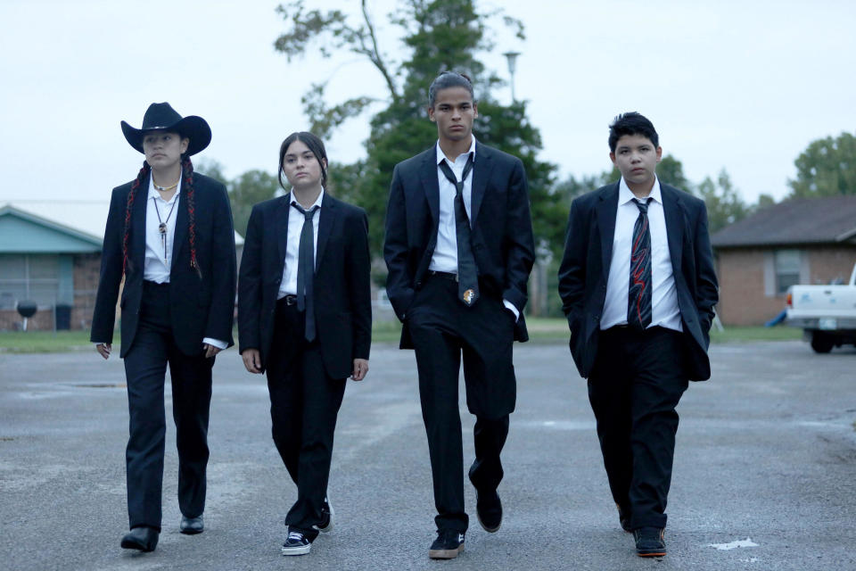 Four teens wearing suits and walking together