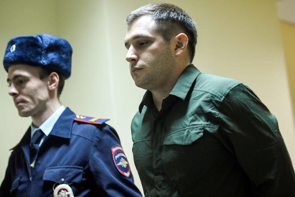 <div class="inline-image__caption"><p>Police officers escort U.S. ex-marine Trevor Reed into a courtroom prior to a hearing in Moscow on March 11, 2020.</p></div> <div class="inline-image__credit">ALEXANDER NEMENOV/AFP via Getty Images</div>