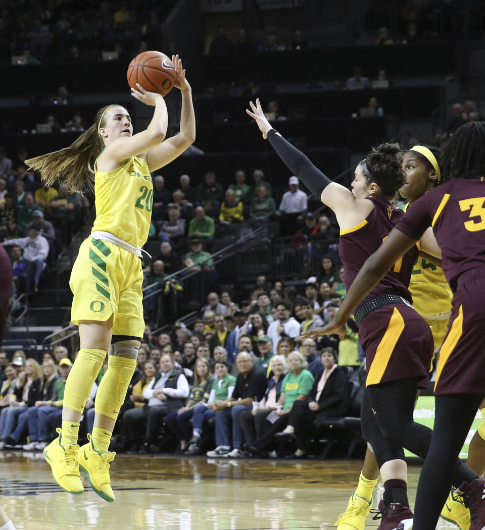 Oregon's Sabrina Ionescu, left, shots over Arizona State's Robbi Ryan, center, and Oregon teammate Ruthy Hebard during the first quarter an NCAA college basketball game Friday, Jan. 18, 2019, in Eugene, Ore. (AP Photo/Chris Pietsch)