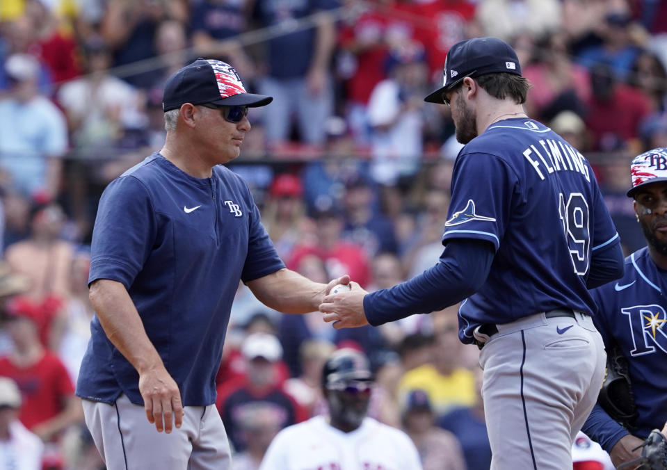 Tampa Bay Rays manager Kevin Cash, left, takes the ball from pitcher Josh Fleming (19) during the eighth inning of a baseball game against the Boston Red Sox at Fenway Park, Monday, July 4, 2022, in Boston. (AP Photo/Mary Schwalm)