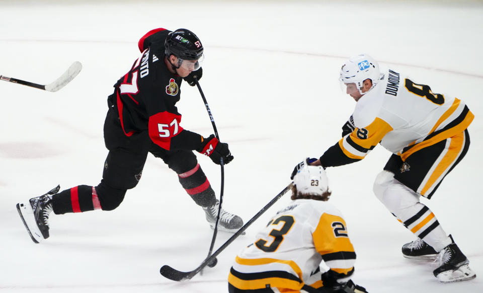 Ottawa Senators center Shane Pinto (57) scores as Pittsburgh Penguins defenseman Brian Dumoulin (8) attempts to block the shot during the third period of an NHL hockey game Wednesday, Jan. 18, 2023, in Ottawa, Ontario. (Sean Kilpatrick/The Canadian Press via AP)