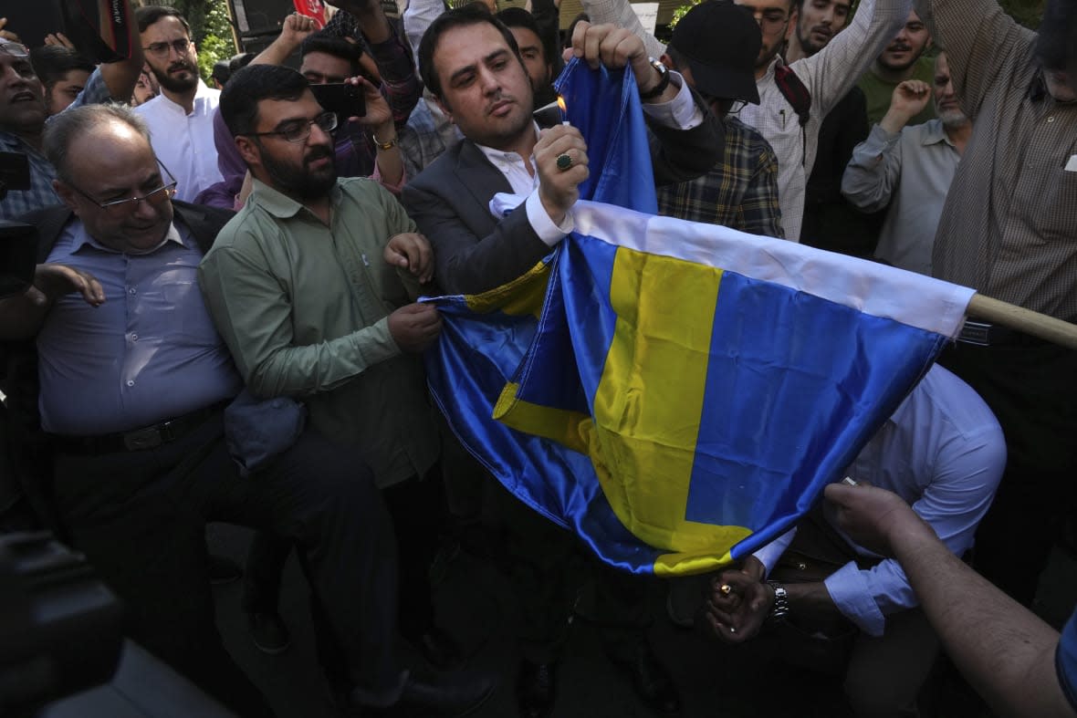 Demonstrators burn a Swedish flag during a protest of the burning of a Quran in Sweden, in front of the Swedish Embassy in Tehran, Iran, Friday, June 30, 2023. A Quran burning and a string of requests to approve the destruction of more holy books have left Sweden torn between its commitment to free speech and its respect for religious minorities. The clash of fundamental principles has complicated Sweden’s desire to join NATO. (AP Photo/Vahid Salemi)
