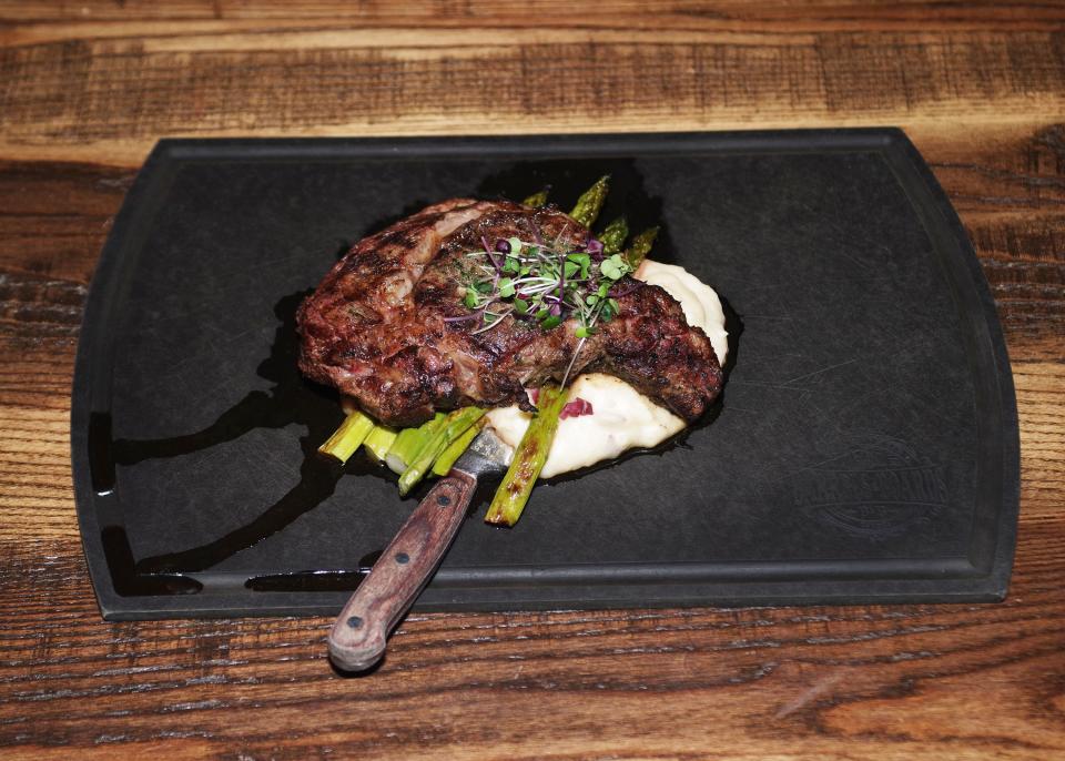 The Delmonico steak with asparagus, potoato, garlic and herb steak butter is available at Barrels & Boards restaurant in Raynham, shown Thursday, Dec. 28., 2023.