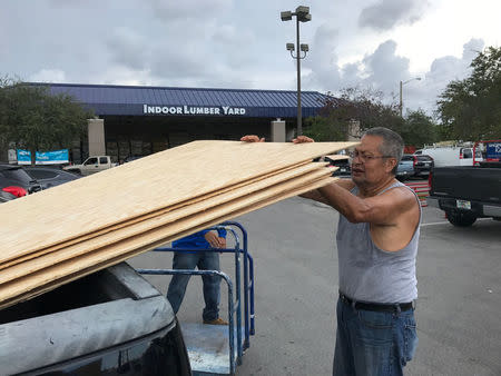 Jerry Garcia, 70, a retired mechanic, loads one of the 20 sheets of plywood he is taking home to prepare for Hurricane Irma at a home supply store in Oakland Park, Florida, U.S., September 5, 2017. REUTERS/Bernie Woodall