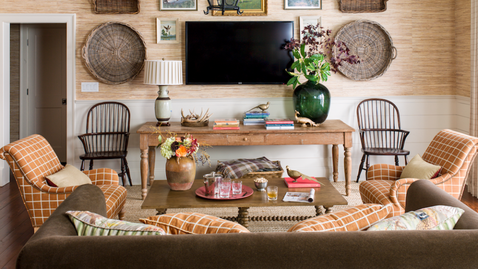 woven baskets and artwork hang around a television in a living room or den