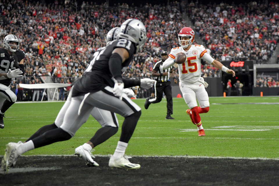 Kansas City Chiefs quarterback Patrick Mahomes (15) scrambles before passing to teammate Jerick McKinnon for a touchdown during the first half of an NFL football game against the Las Vegas Raiders Saturday, Jan. 7, 2023, in Las Vegas. (AP Photo/David Becker)