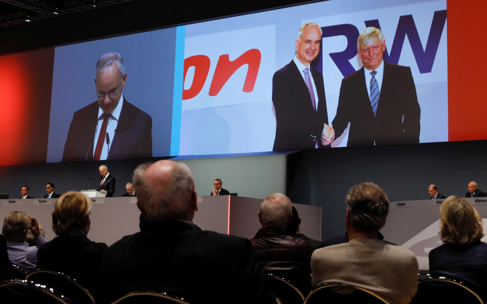 A picture of the handshake of E.ON CEO Johannes Teyssen (L) and RWE CEO Rolf Martin Schmitz, marking the planned merger of the two German utilities, is displayed on a screen as EO.N CEO Teyssen addresses the company's annual shareholder meeting in Essen, Germany, May 14, 2019. REUTERS/Wolfgang Rattay