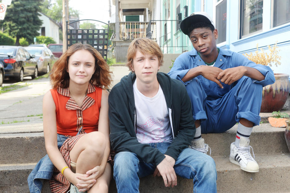 Olivia Cooke, Thomas Mann, and RJ Cyler sit on a stoop